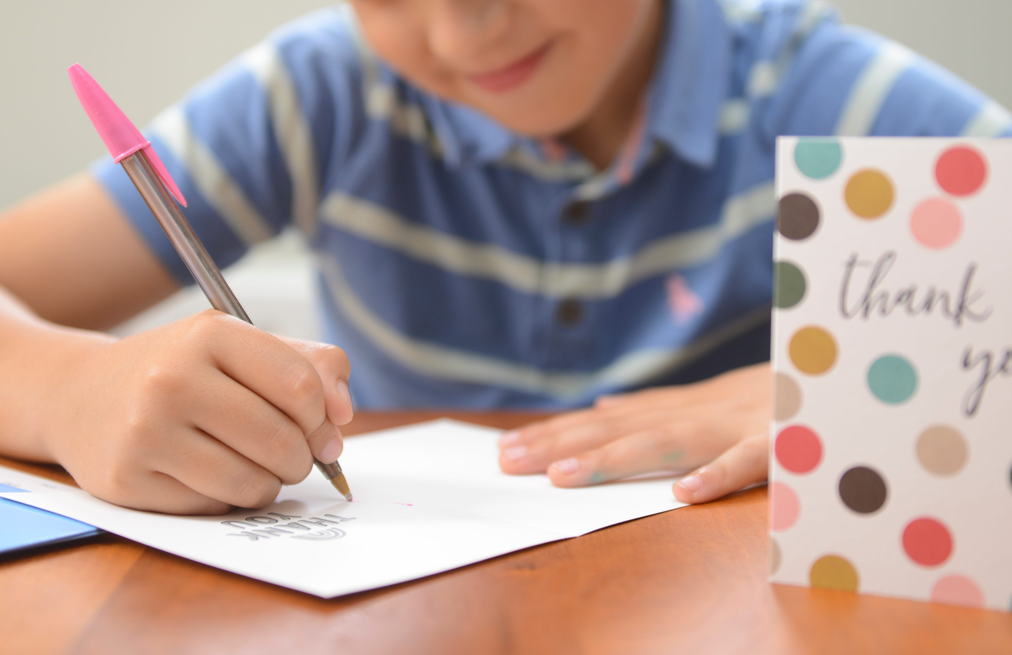 A young boy writes a thank you note