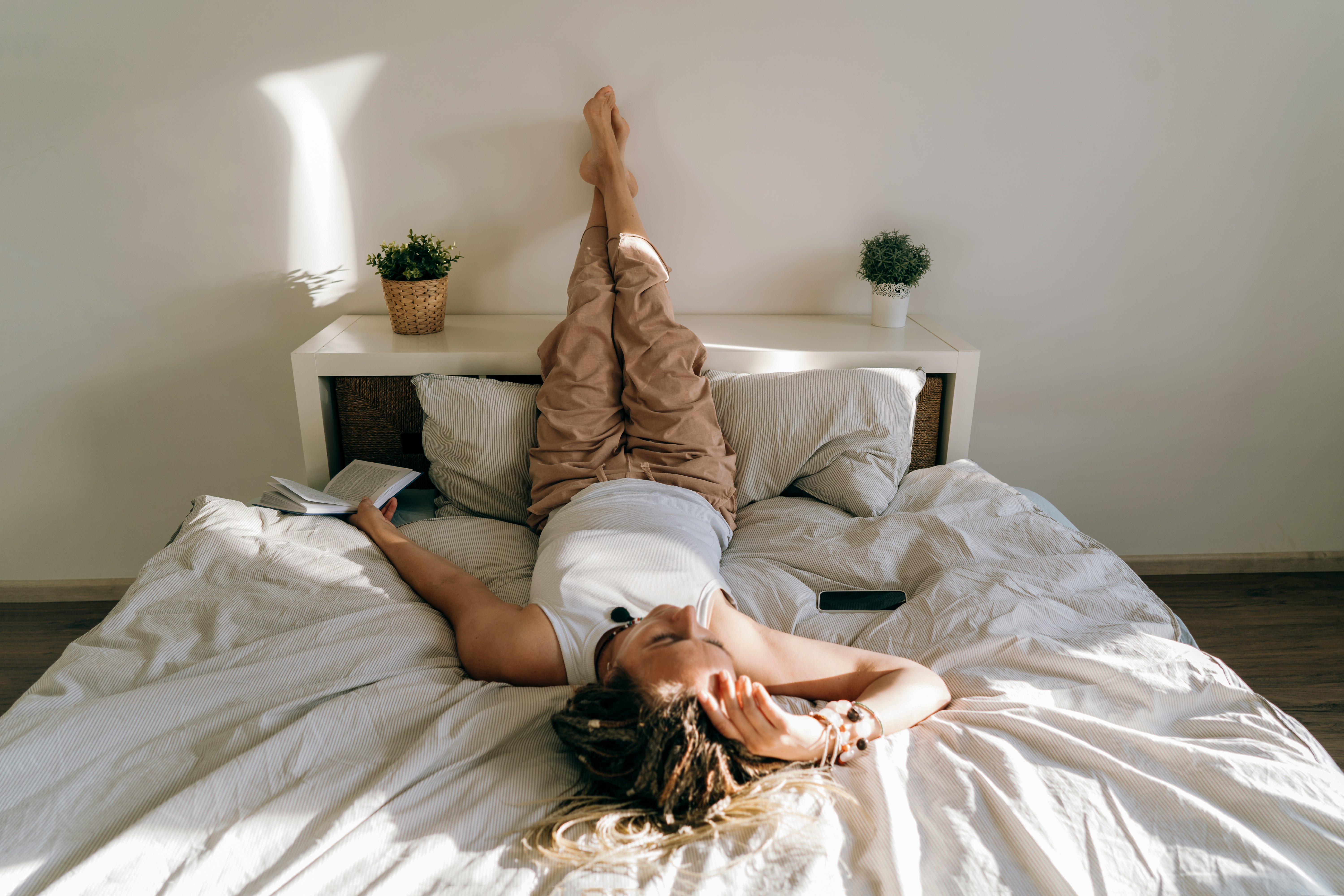 A woman relaxes in bed.