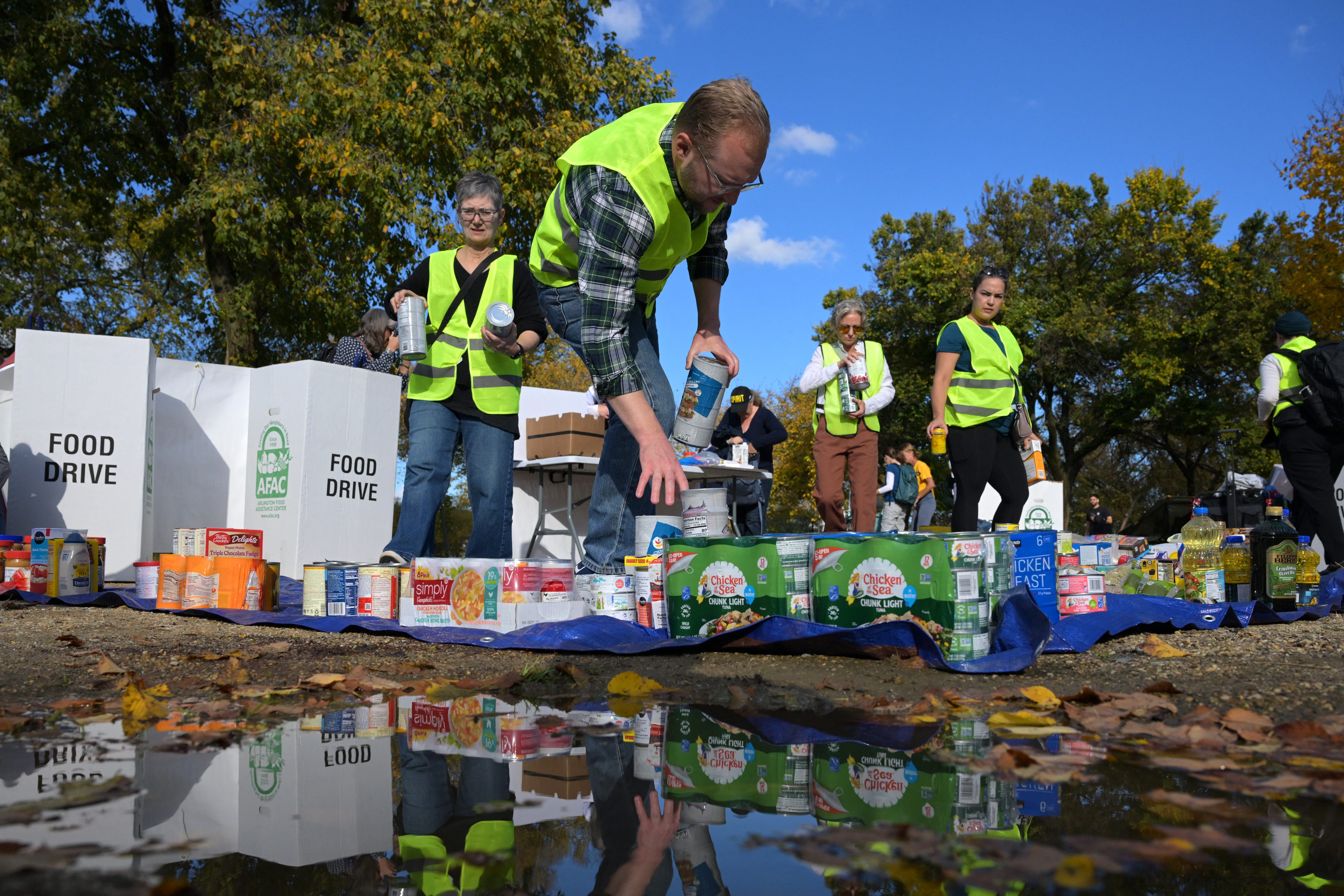Volunteers place groceries during the People's Pantry Food drive to replenish food banks ahead of SNAP lapse at the USDA Headquarters.