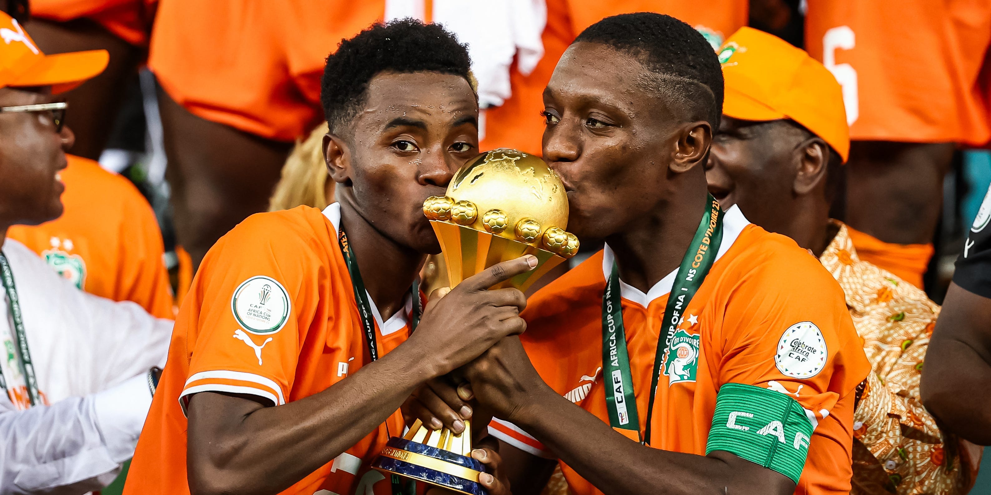 Ivory Coast's Max-Alain Gradel and Simon Adingra kiss the Africa Cup of Nations trophy on the podium after Ivory Coast won the Africa Cup of Nations 2024.