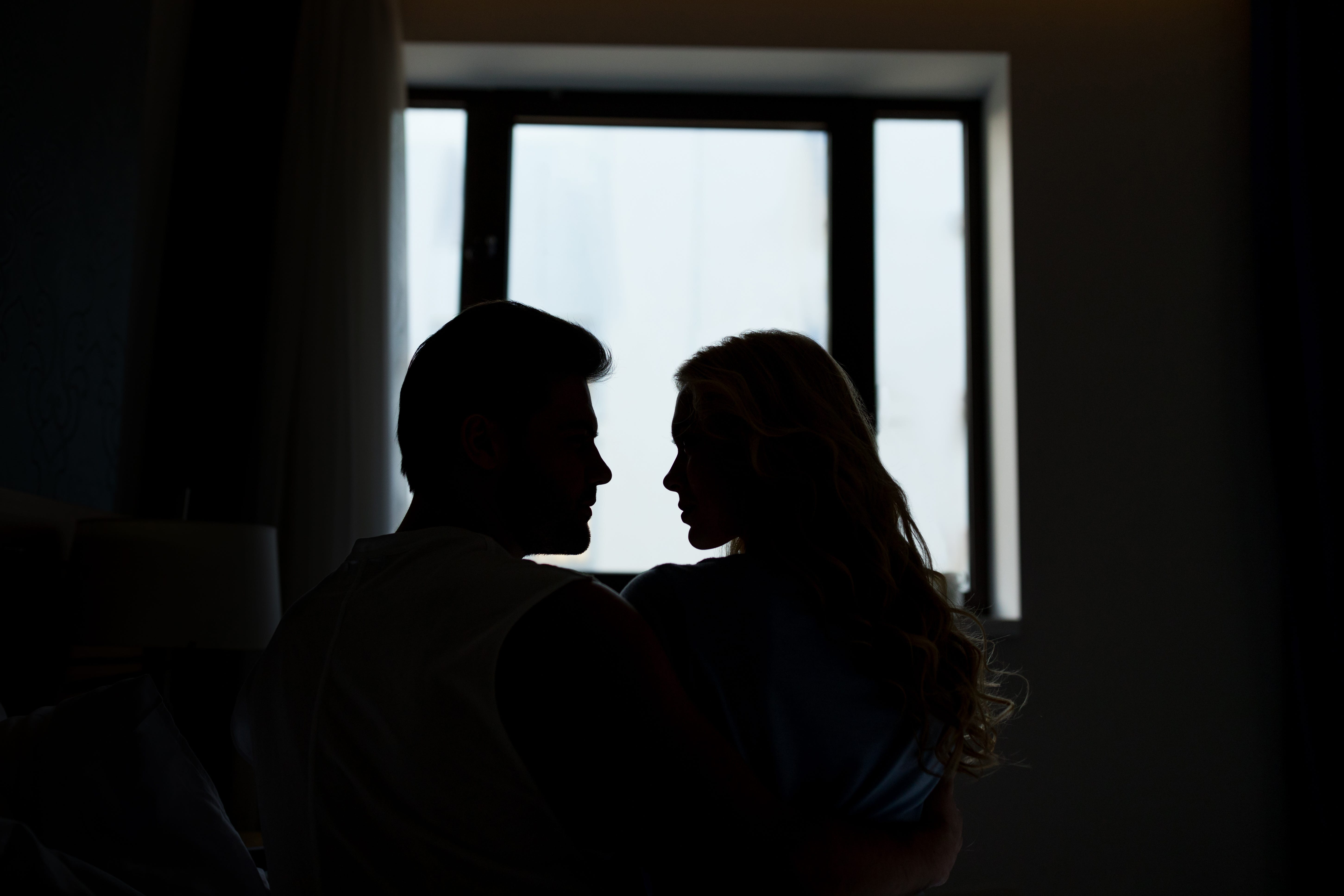 The silhouette of a couple embracing each other.