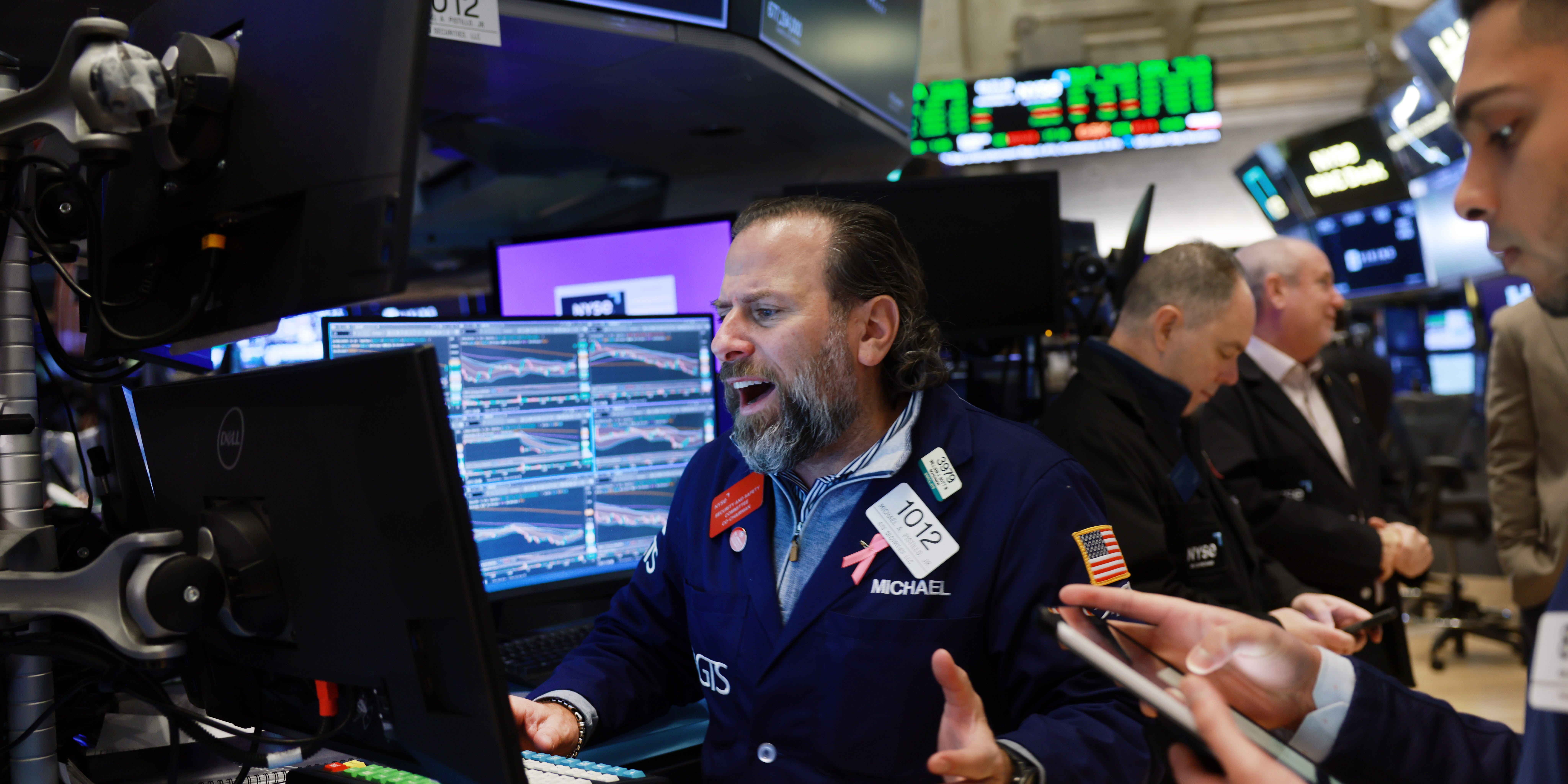 NYSE stock trader speaking excitedly in front of a screen