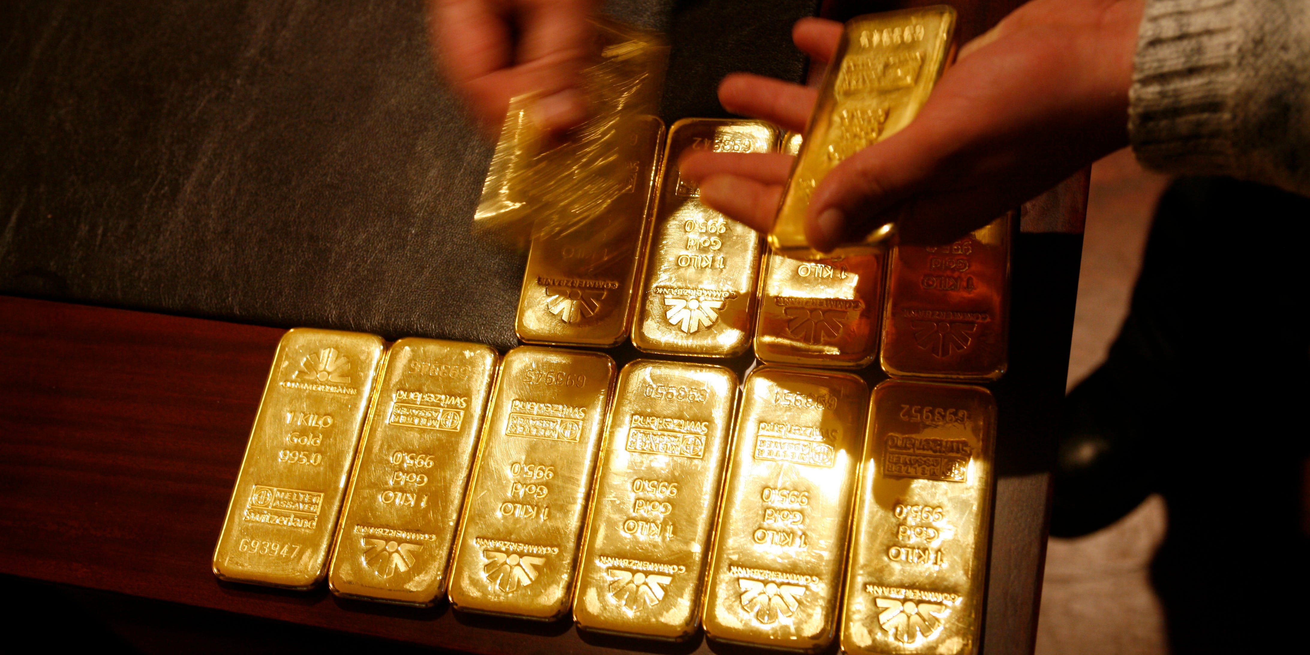 Person laying down gold bars on a table