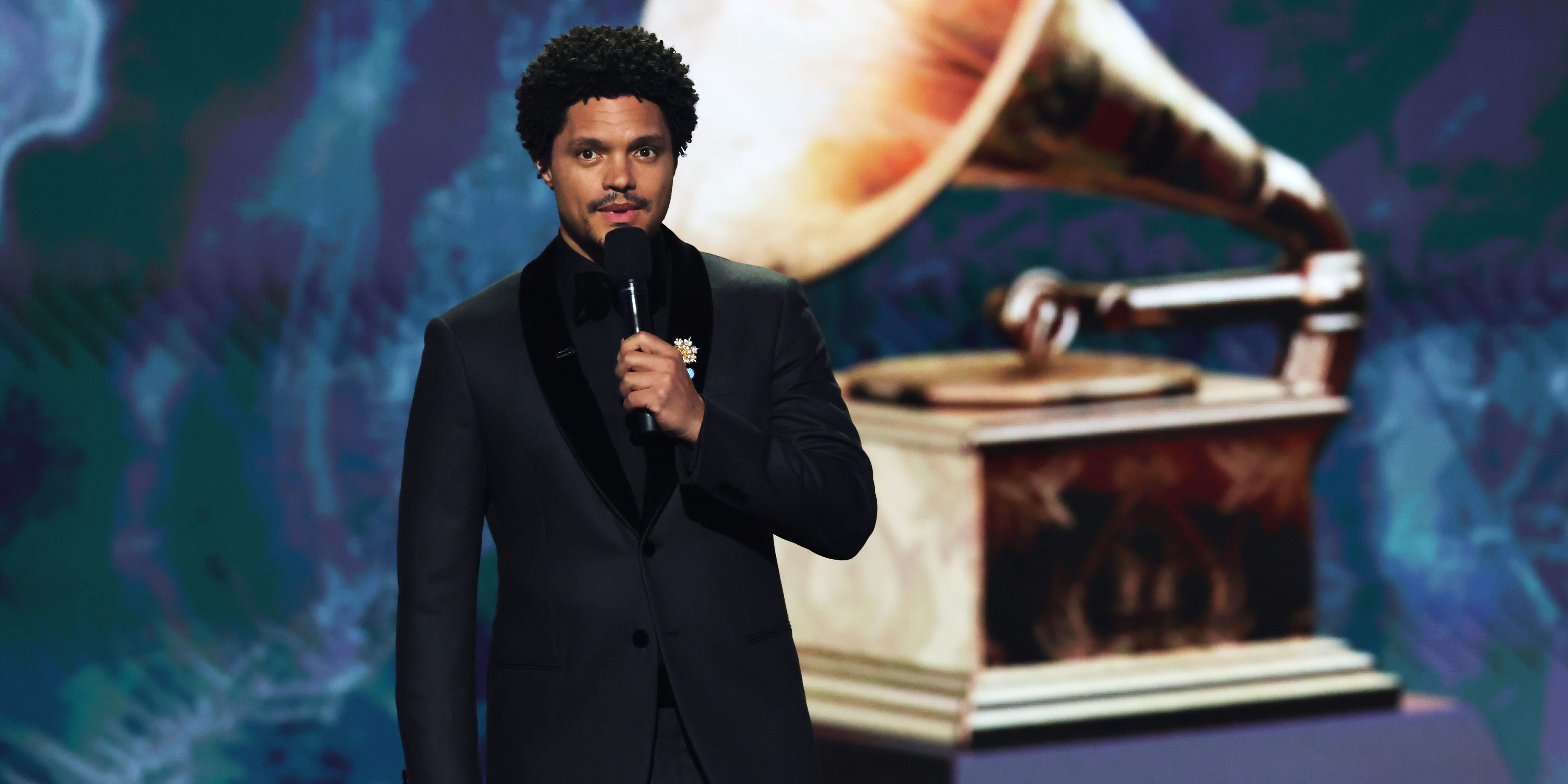 Trevor Noah holds a microphone as he hosts the 2025 Grammy Awards.