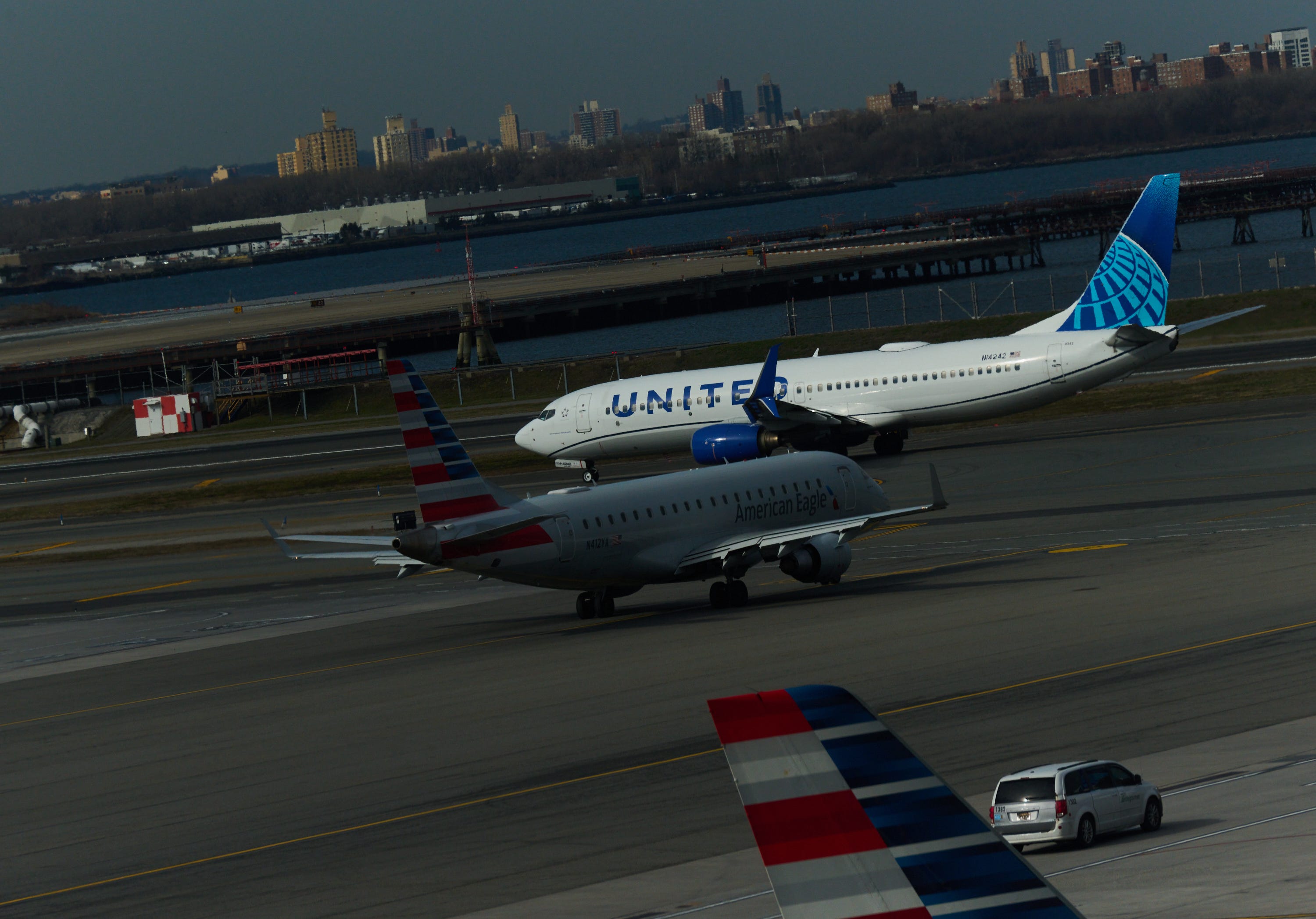 A United Airlines 767-300ER is seen at a gate with the Manhattan skyline in the background at Newark Liberty International Airport in Newark, New Jersey, on March 18, 2026. US airport security officers missed their first full paycheck on March 13 as a partial funding<br /><a href=