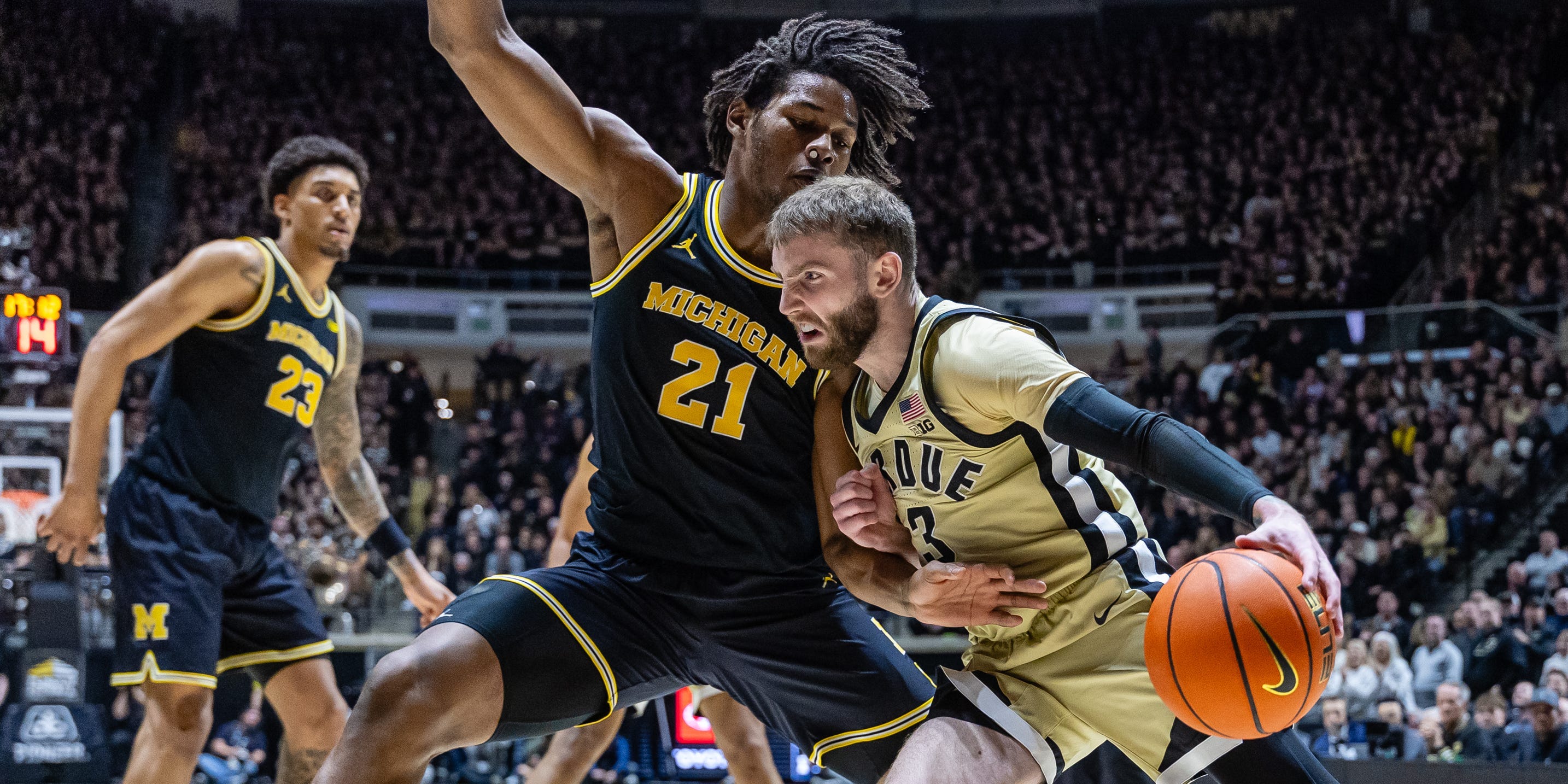 Braden Smith #3 of the Purdue Boilermakers drives to the basket against Morez Johnson Jr. #21 of the Michigan Wolverines while a crowd watches on during a<br /><a href=